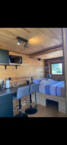 una camera con letto e scrivania in una cabina di La Tiny house ad Ardres