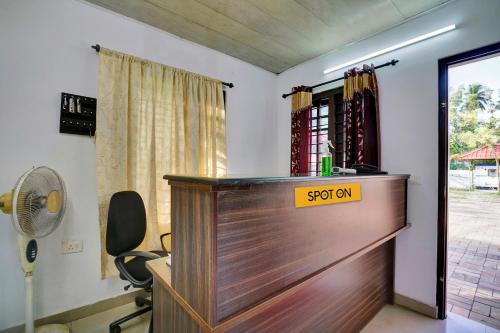 a desk with a sign on it in a room at SPOT ON 81230 J Square in Trivandrum