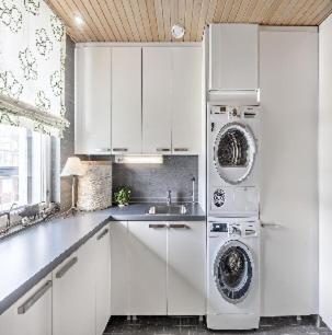 eine Küche mit weißen Schränken und einer Waschmaschine in der Unterkunft Serrano**** in Porto Rotondo