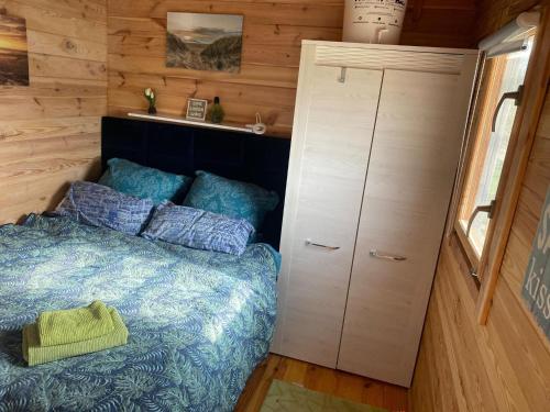 um quarto com uma cama numa pequena casa em Holiday home with private sauna and jacuzzi em Stepnica