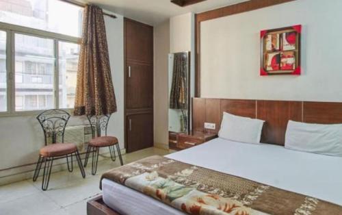 Schlafzimmer mit einem Bett, einem Tisch und Stühlen in der Unterkunft Hotel Indo Continental in Neu-Delhi