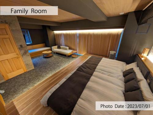 a bedroom with a large bed and a living room at HOTEL TOMOS ASAKUSA in Tokyo