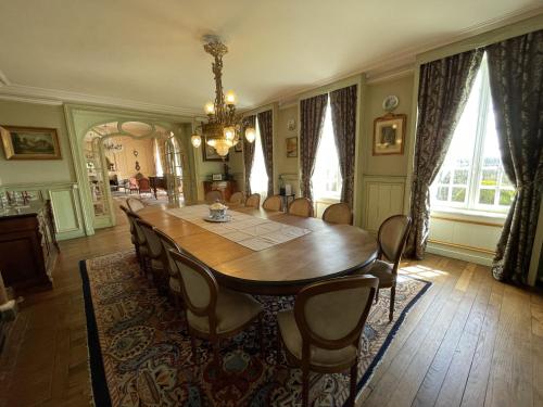 a dining room with a wooden table and chairs at Chateau La Rametiere in Plomb