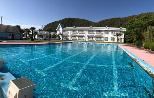 a large swimming pool in front of a building at パームビーチリゾートホテル in Oshima