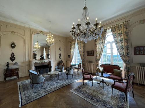 a living room with chairs and a chandelier at Chateau La Rametiere in Plomb