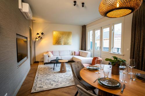 a living room with a table and a couch at Luxe Appartement nabij centrum in Zwolle