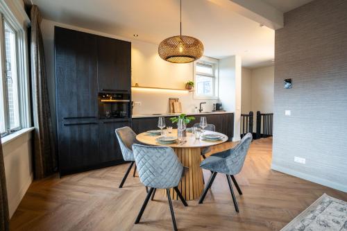 a dining room and kitchen with a table and chairs at Luxe Appartement nabij centrum in Zwolle