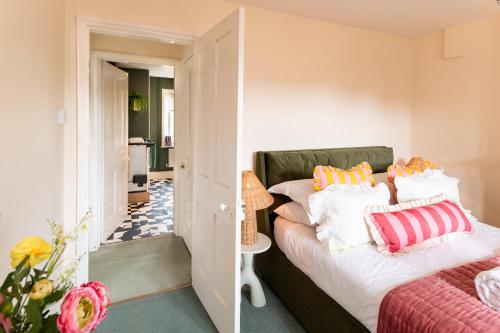 a bedroom with a bed with colorful pillows on it at Estate Lodge Sleeps 5 on The Jurassic Coast Devon in Sidbury