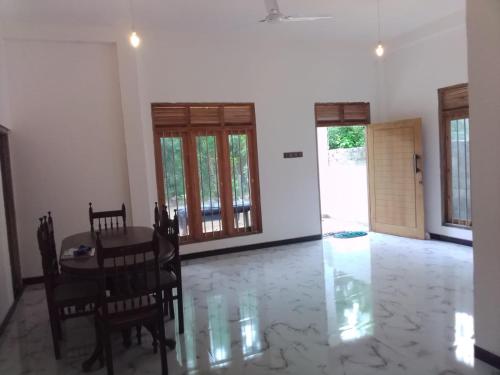 a dining room with a table and chairs at Wijesingha Holiday Home in Weligama