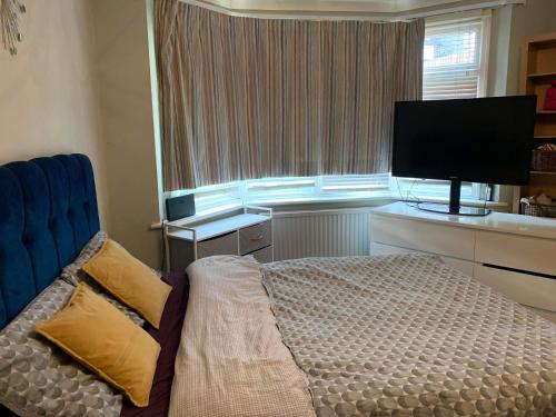 a bedroom with a bed and a flat screen tv at Private Lovely double bedroom in High Wycombe