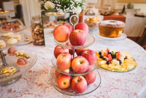 a table topped with plates of apples and other desserts at Hotel Villa Ida in Ceprano