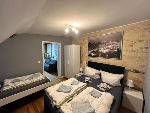 een slaapkamer met 2 bedden en een bakstenen muur bij Flensburg Zentrum 69 03 in Flensburg