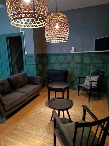 un salon avec un canapé, une table et des chaises dans l'établissement Maison Salomé en hyper centre (intégralement rénovée et équipée), à Saint-Omer