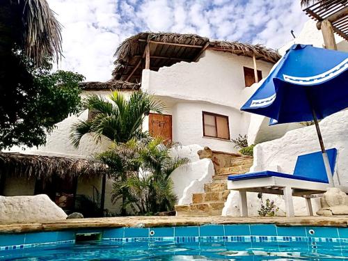 カノアス・デ・プンタ・サルにあるHotel Smiling Crabの家の横の青い傘と椅子