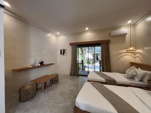 a hotel room with two beds and a table at Lio Villas Resort in El Nido