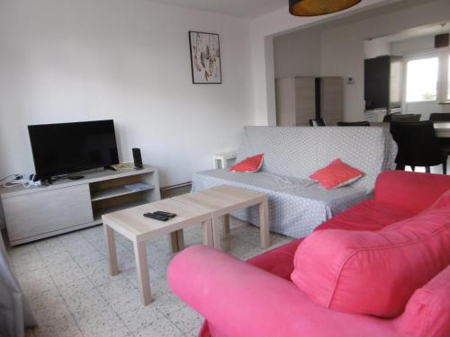a living room with a pink couch and a table at Buisseret in Seneffe