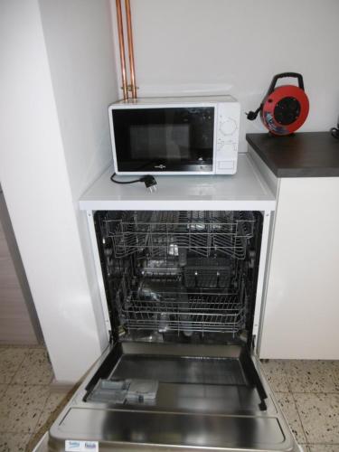 a microwave oven sitting on top of a dishwasher at Buisseret in Seneffe