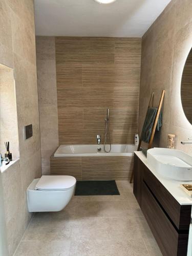 a bathroom with a tub and a toilet and a sink at Marsaxlokk Sea Front Apartment in Marsaxlokk