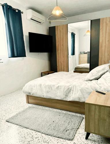 a bedroom with a large bed and a television at Marsaxlokk Sea Front Apartment in Marsaxlokk