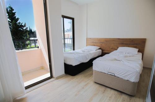 two beds in a room with a large window at SEASIDE APART OTEL- 400 meter to sea! in Side