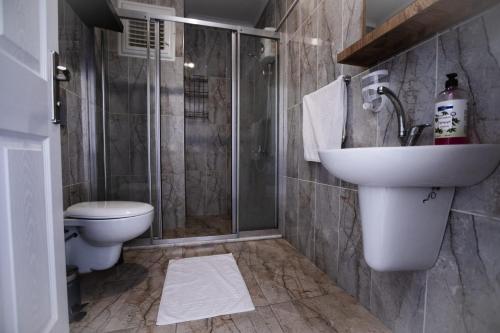La salle de bains est pourvue de toilettes, d'un lavabo et d'une douche. dans l'établissement SEASIDE APART OTEL- 400 meter to sea!, à Sidé