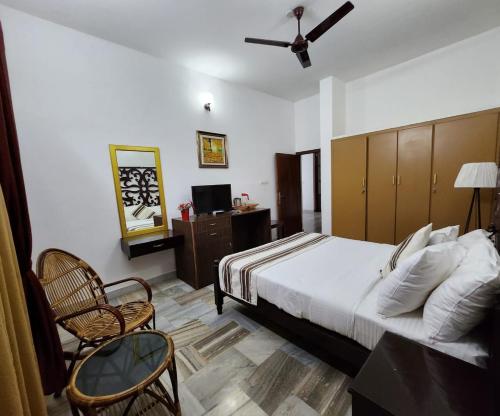 een slaapkamer met een bed en een tafel en stoelen bij Bharatham Heritage Inn in Kannur