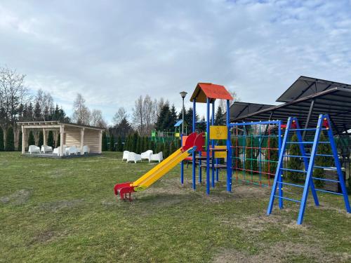 plac zabaw z żółto-niebieską zjeżdżalnią i zjeżdżalnią w obiekcie Apartamenty Baltyk w Karwii