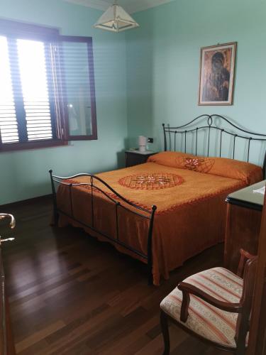 a bedroom with a bed and a chair and a window at Il Casale del Sole in Tossicia