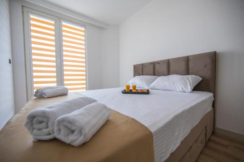um quarto com uma cama grande e toalhas em CEVAHIR SKY CITY Skopje JK Apartments em Skopje