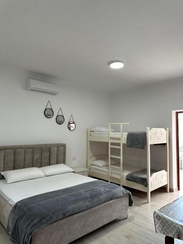 a bedroom with a bed and two bunk beds at Davide's guesthouse in Vlorë