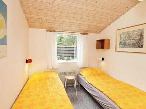 2 camas en una habitación pequeña con ventana en Holiday Home Foldenvej, en Jerup