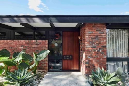 a brick house with a wooden entry door at Sibbel House- Luxurious Mid-Century Modern Home, Yarra Valley in Healesville