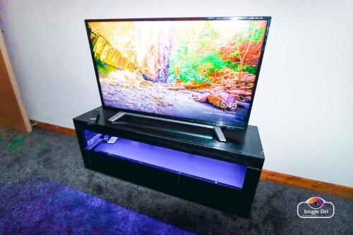 a flat screen tv sitting on a black stand at Stunning Flats in Handsworth Birmingham Close to ONE STOP Perry barr andAston Football club in Birmingham
