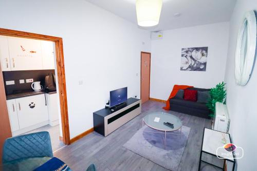 a living room with a couch and a table at Stunning Flats in Handsworth Birmingham Close to ONE STOP Perry barr andAston Football club in Birmingham