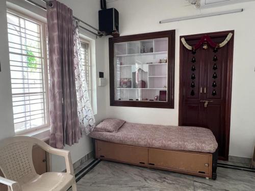 a room with a bed and a mirror and a chair at 2BHK with parking & ample space in Bangalore