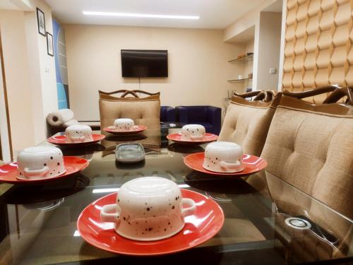 een kamer met een tafel met bekers en borden erop bij Alvi's Home in Dhaka