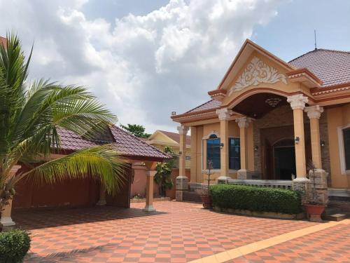 a house with a palm tree in front of it at Leng Seng Na Hotel in Battambang