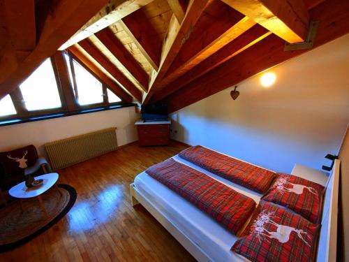a bedroom with a bed in a room with wooden ceilings at Mendel Stube in Cavareno