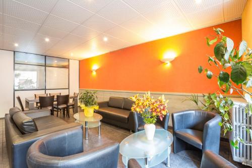 a waiting room with couches and tables and chairs at Logis SPA Hotel Restaurant De La Poste in Tence