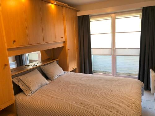 - une chambre avec un lit et une grande fenêtre dans l'établissement Seastar, à Saint-Idesbald