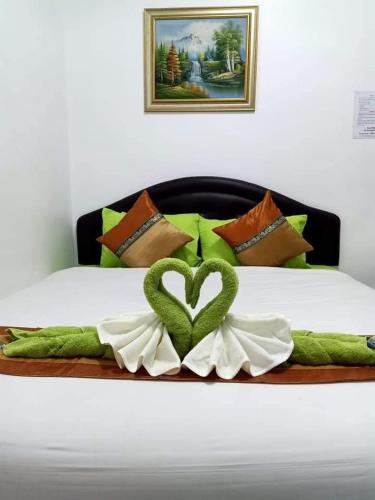 a bed with a green heart on top of it at Greenhouse homestay betong in Betong