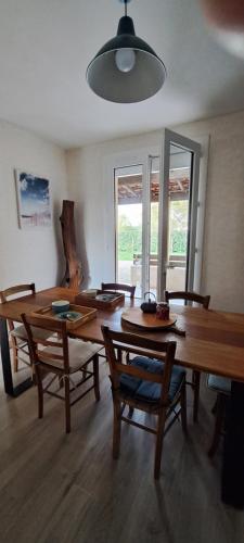 uma sala de jantar com mesas e cadeiras de madeira num quarto em Logi du carabin em Brax