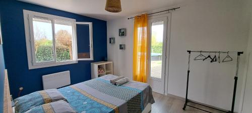 - une chambre avec un lit et un mur bleu dans l'établissement Logi du carabin, à Brax