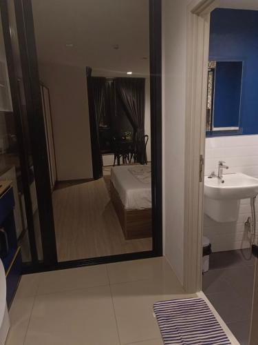 a bathroom with a mirror and a bed and a sink at The base central phuket in Phuket