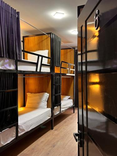 a room with three bunk beds and a door at Al Bukhari Boutique Hotel in Bukhara