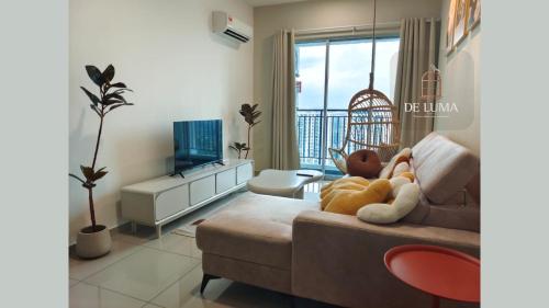 uma sala de estar com um sofá e uma televisão em De Luma-Metropol 3Bedrooms em Bukit Mertajam