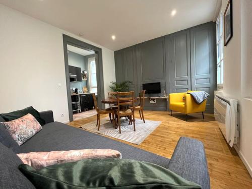 ein Wohnzimmer mit Sofa und Tisch in der Unterkunft Au pied du château in Azay-le-Rideau