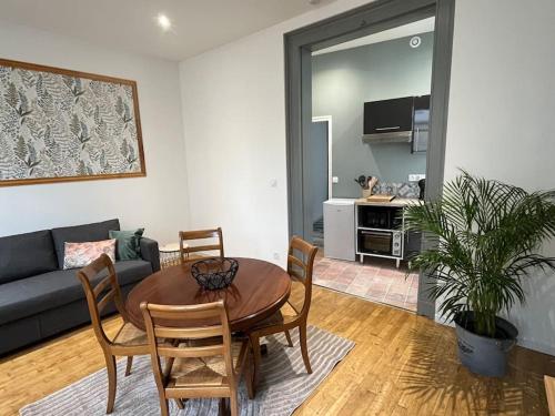 un salon avec une table, des chaises et un canapé dans l'établissement Au pied du château, à Azay-le-Rideau