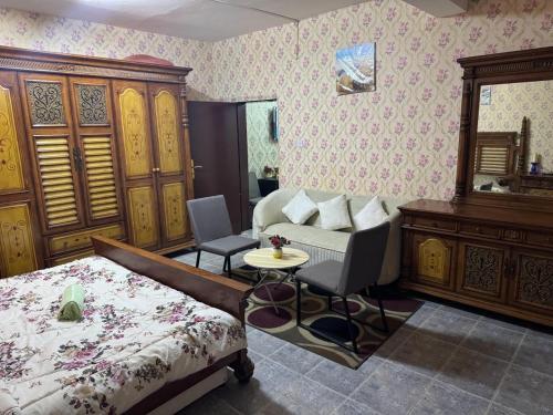 een slaapkamer met een bed, een bureau en een tafel bij العين الهيلي مصباح ب 5 in Al Ain