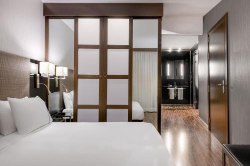 ブレシアにあるAC ホテル ブレシア ア マリオット ライフスタイル ホテルのベッドとバスルーム付きのホテルルームです。